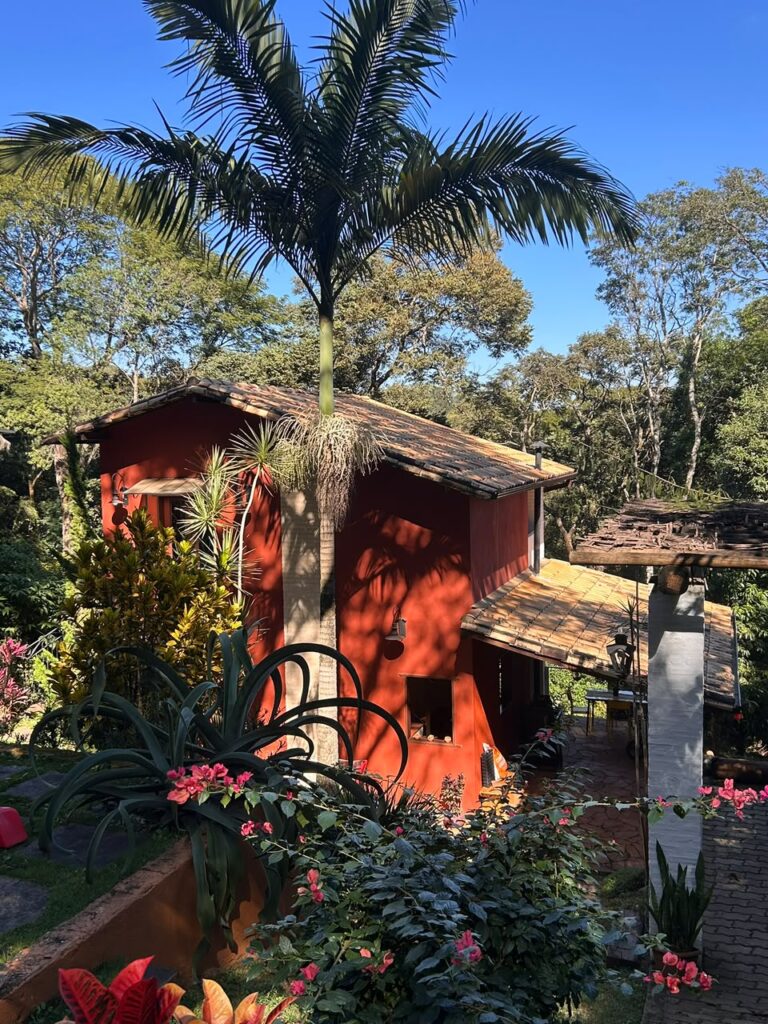 Casa estilo chalé com varanda, pomar, jardins e vista para área preservada